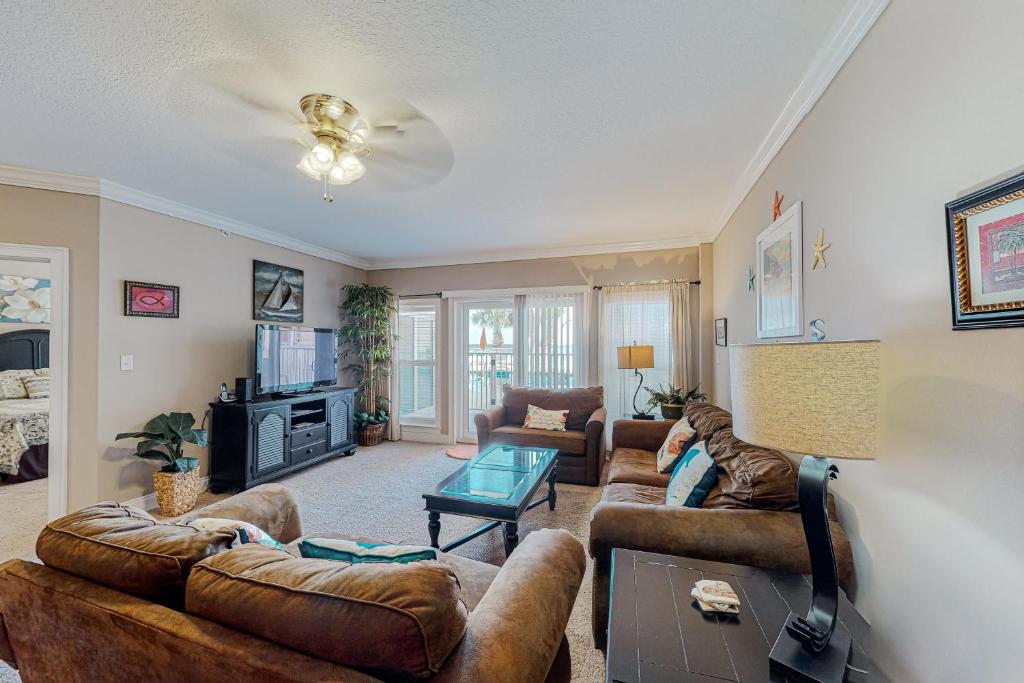 a living room with two couches and a tv at Paradise Shores 105 in Mexico Beach