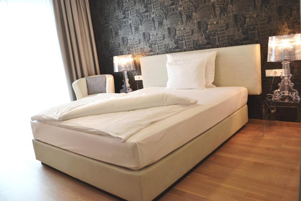 uma grande cama branca num quarto com em City Hotel em Linz