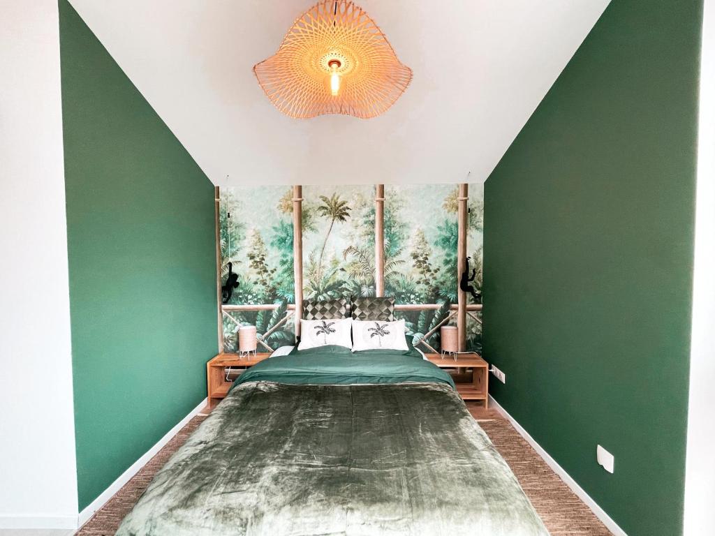 1 dormitorio con 1 cama con pared verde en Studio Jungle Ludres, en Ludres