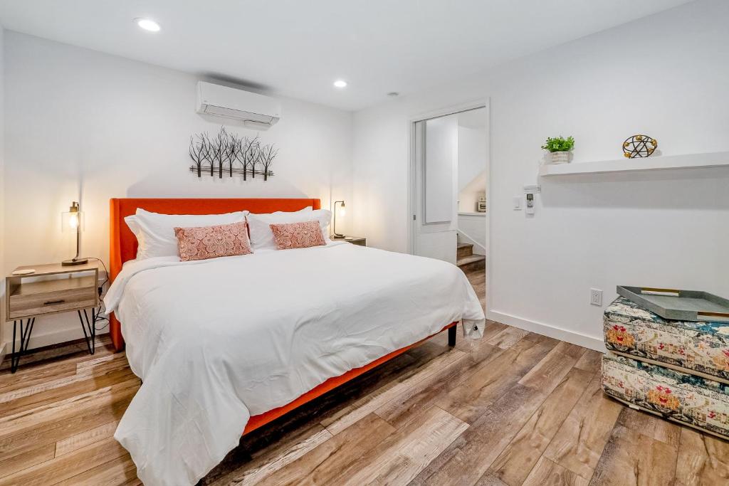 a bedroom with a large white bed and wooden floors at Sweet Escape in San Diego
