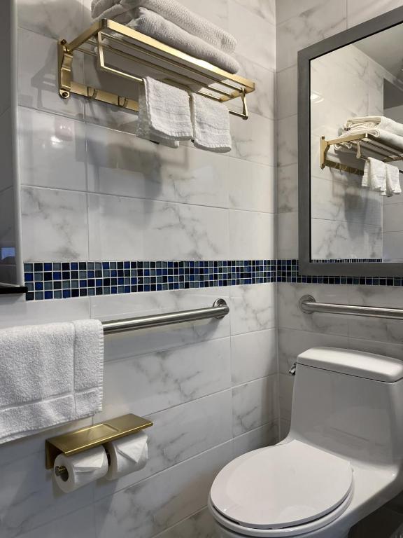 a bathroom with a toilet and a mirror and towels at Hotel Richland LES in New York