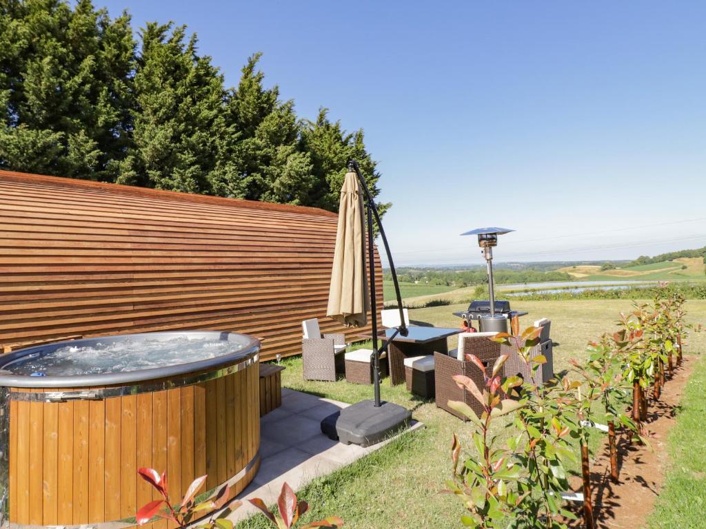 a hot tub in a garden next to a wooden fence at Ailsa Craig in Worcester