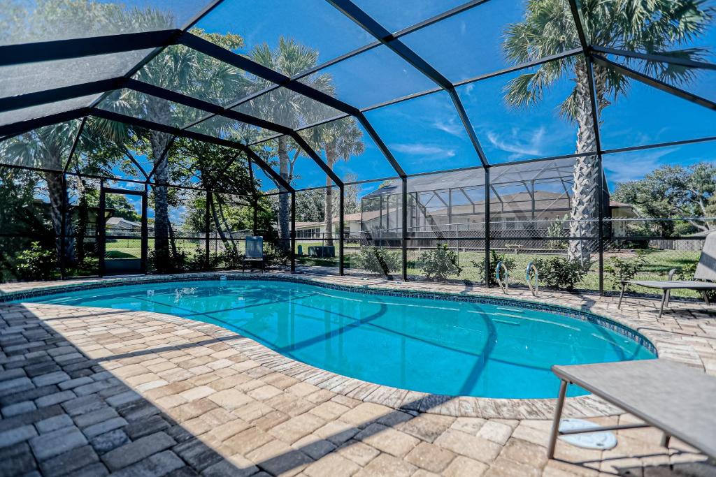 een zwembad in een gebouw met een glazen wand bij Sunny Palms Getaway in Palm Coast