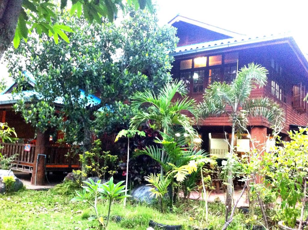 dom z drzewami i roślinami przed nim w obiekcie Samnaree Garden House w mieście Ban Phae Mai