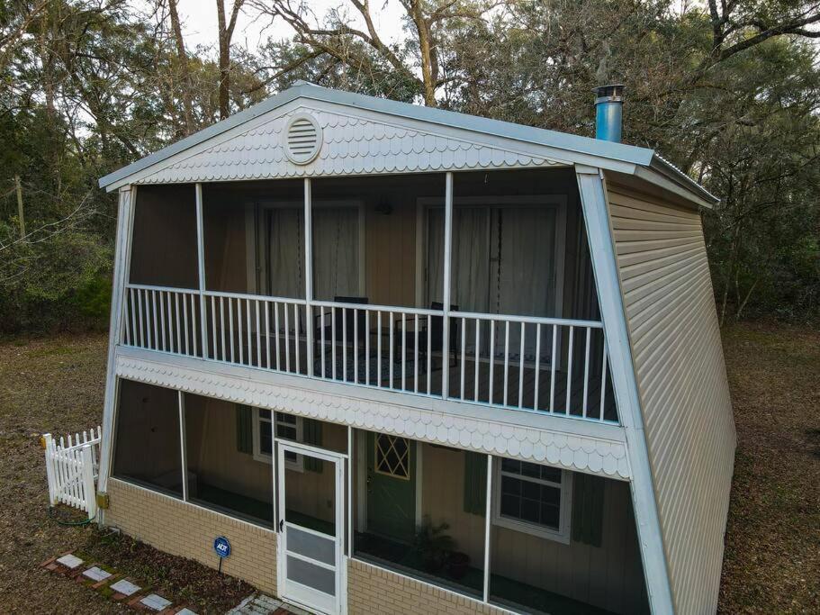 a large house with a balcony on top of it at Huck's Hideaway near the Santa Fe River in Fort White