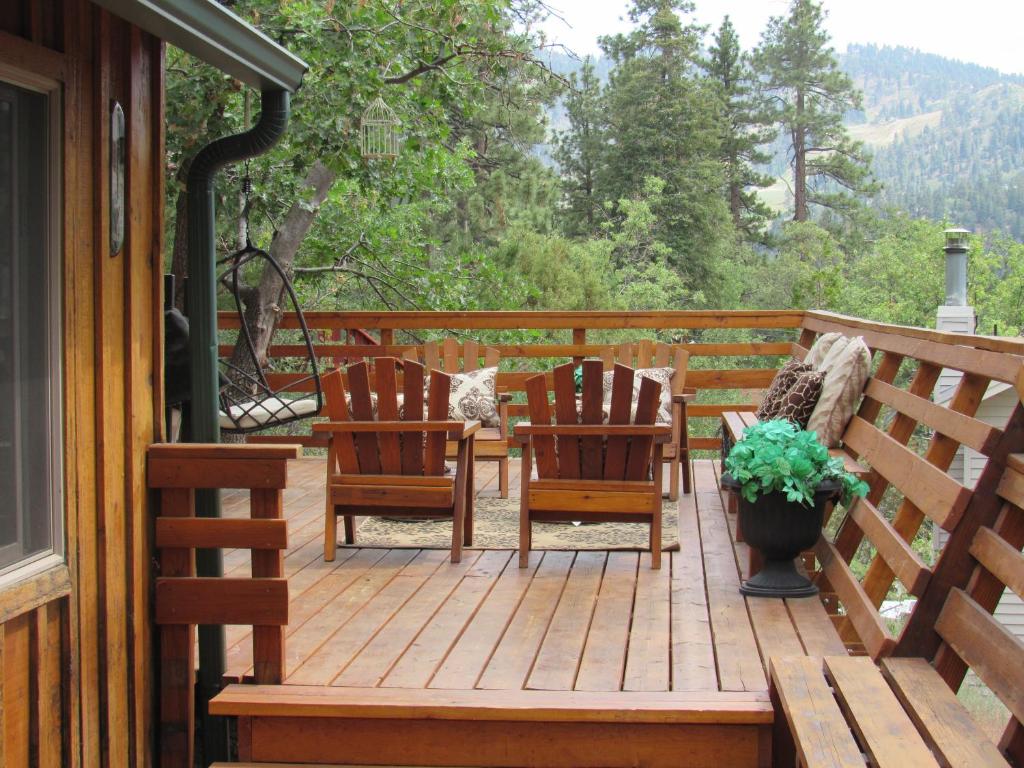 two chairs and a table on a wooden deck at Hillside Hideaway -View of Ski Slope from Charming Deck in Big Bear Lake