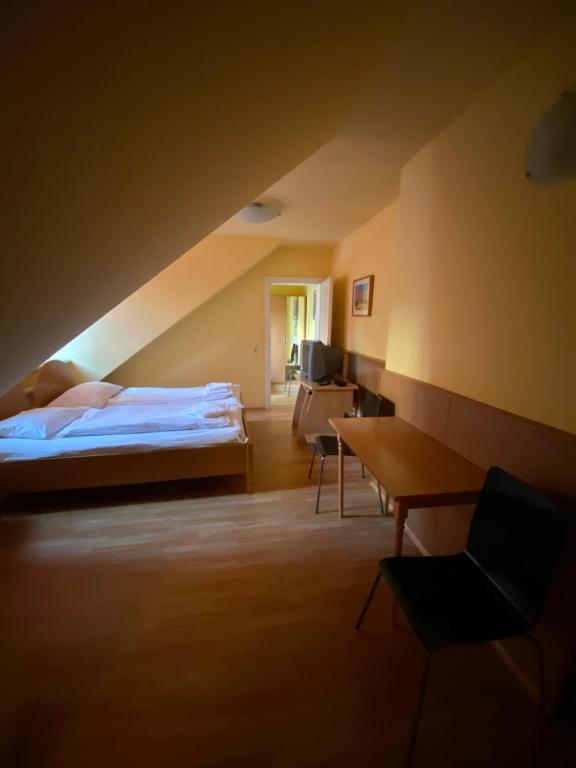 ウィーンにあるアパートメント ペンション 700m ツム リングのベッドルーム1室(ベッド1台、デスク、椅子付)