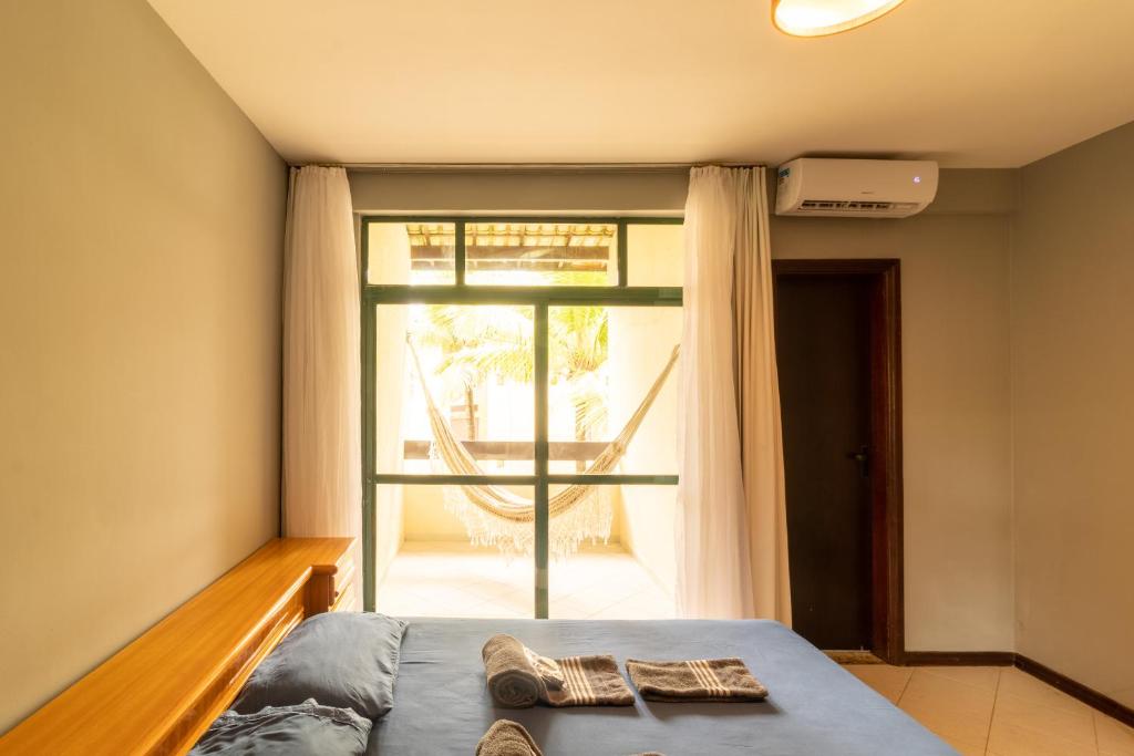 a bedroom with a bed and a large window at Beira Mar Salvador Bahia Brazil climatizado in Salvador