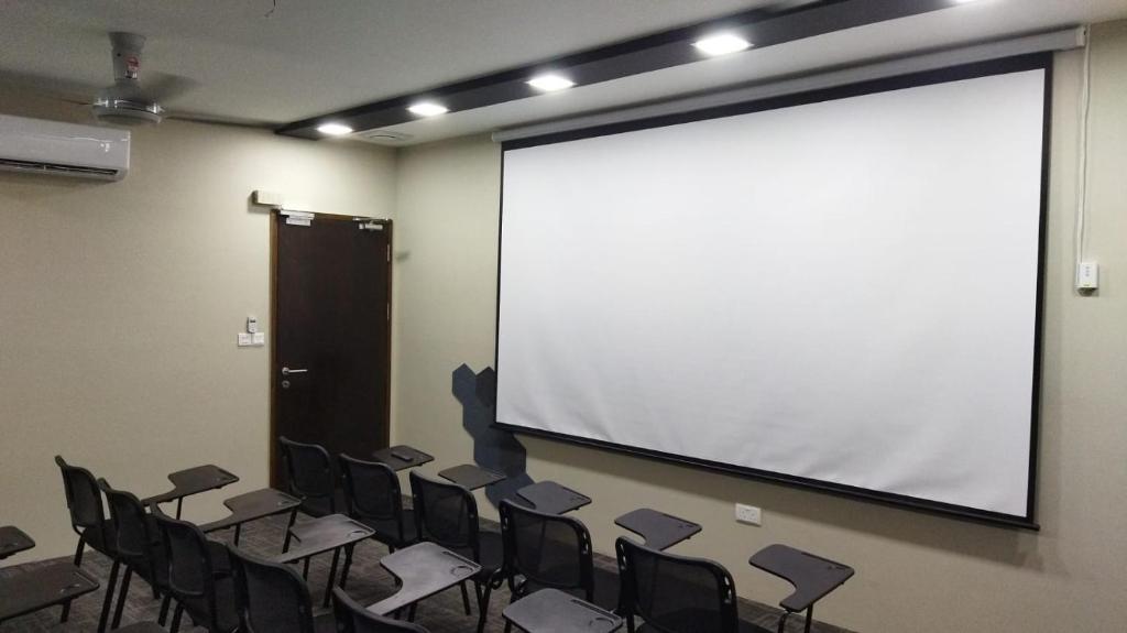a conference room with chairs and a large screen at Qing Yun Rest House Koprijaya, Brunei Darussalam in Bandar Seri Begawan