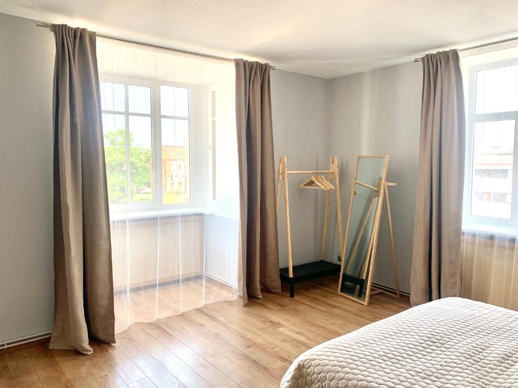 sypialnia z łóżkiem i 2 oknami z zasłonami w obiekcie Two bedroom apartment Barinu street w mieście Lipawa
