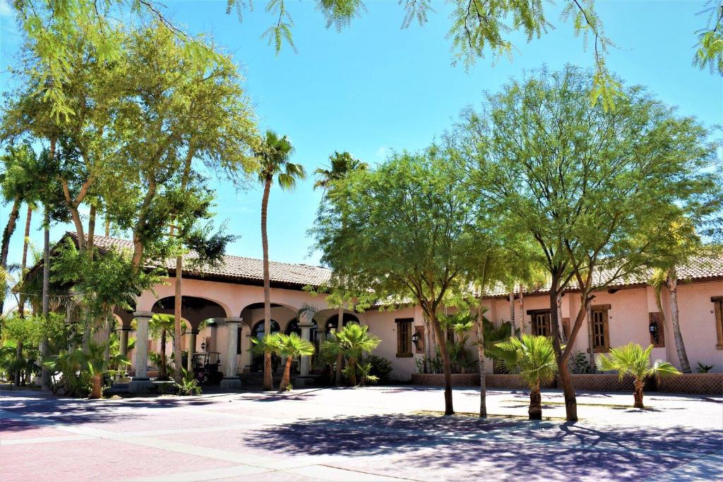 a building with palm trees in front of it at HACIENDA MONARCAS Resort in Puerto Peñasco