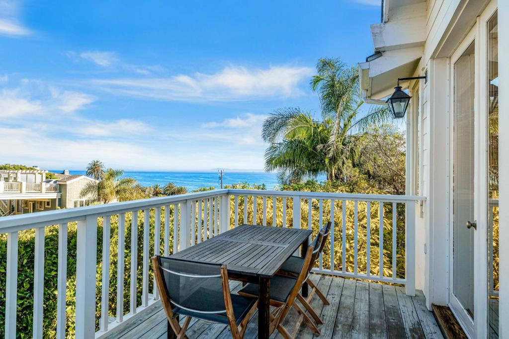 een tafel en stoelen op een balkon met uitzicht op de oceaan bij Golden Getaway in Summerland