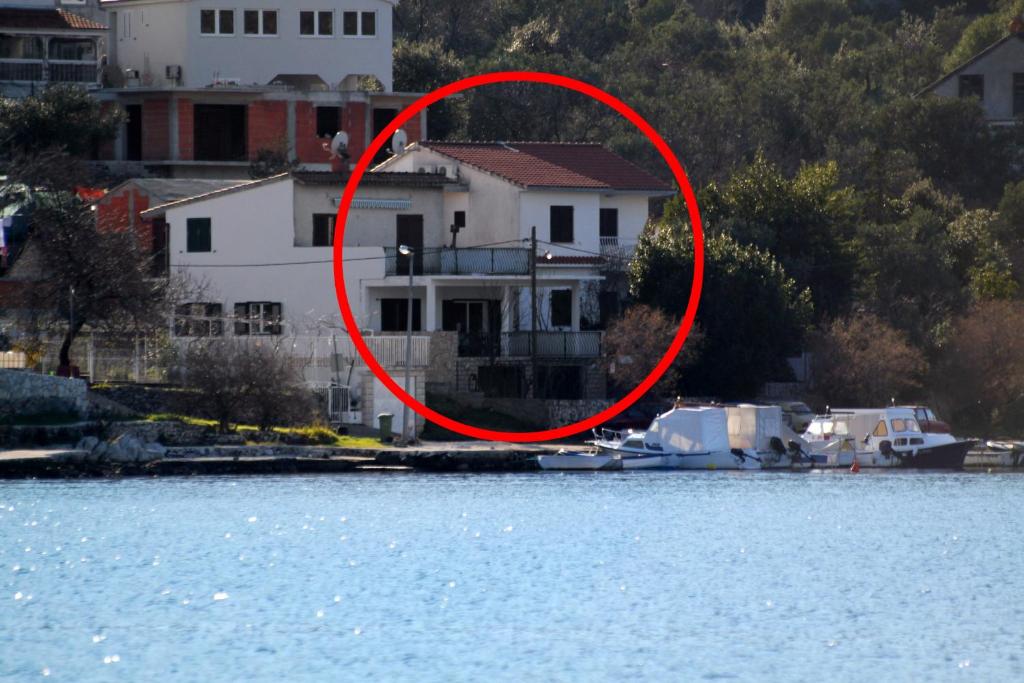 a red circle around a house on the water at Apartments by the sea Vinisce, Trogir - 5982 in Vinišće