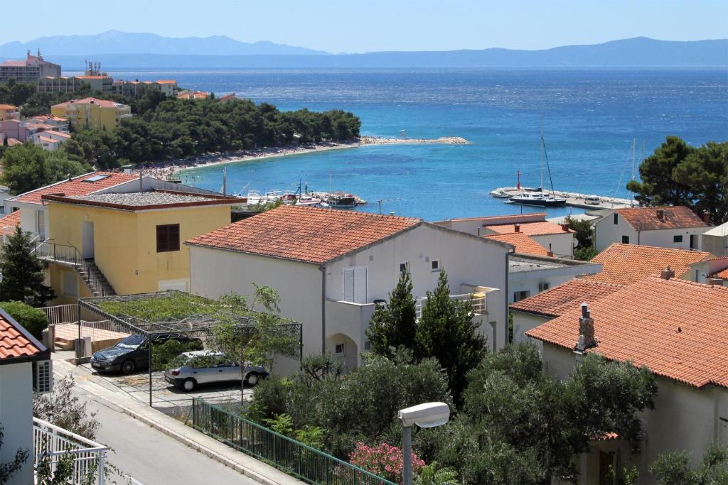 a view of a town with houses and the ocean at Apartment Baska Voda 6057c in Baška Voda