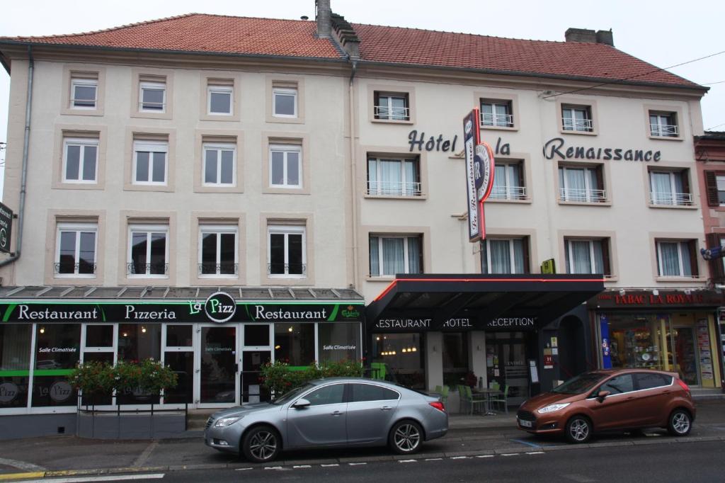 due auto parcheggiate di fronte a un grande edificio di Logis Hôtel- Restaurant La Renaissance a Baccarat