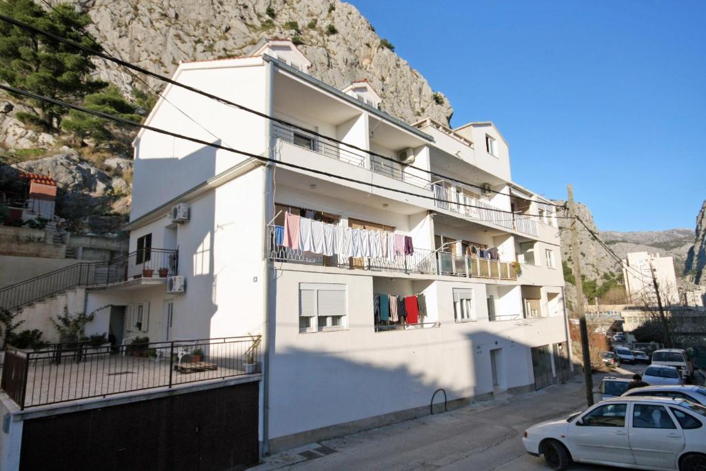a white building with clothes hanging on a balcony at Apartments with a parking space Omis - 5988 in Omiš