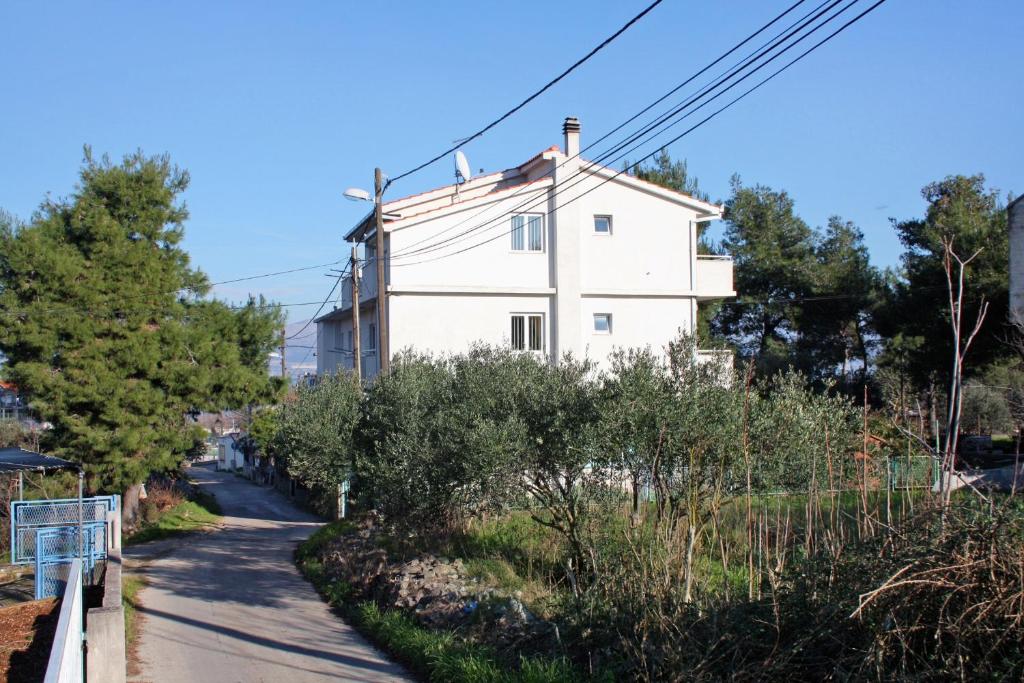 een wit huis aan de kant van een weg bij Apartments with a parking space Slatine, Ciovo - 5999 in Slatine