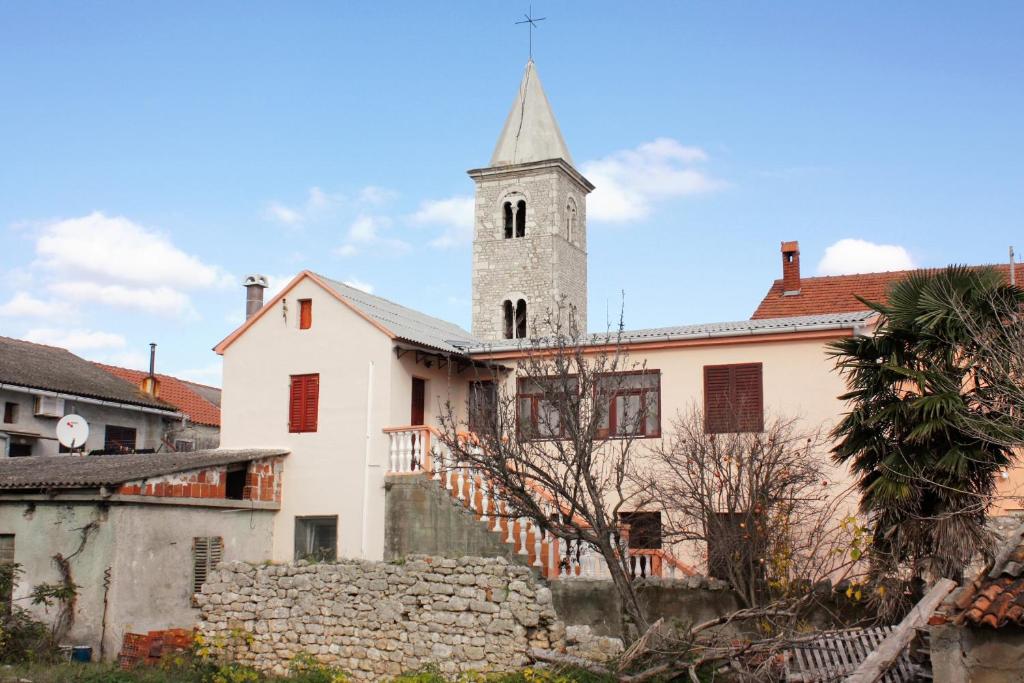 een kerk met een toren op een gebouw bij Apartments by the sea Nin, Zadar - 5937 in Nin