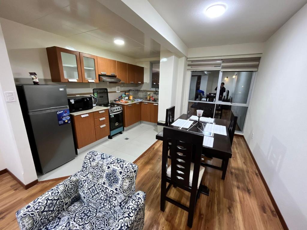 uma cozinha e sala de estar com mesa e cadeiras em Moderno y Cómodo Apartamento con la Mejor Ubicación en Sopocachi em La Paz