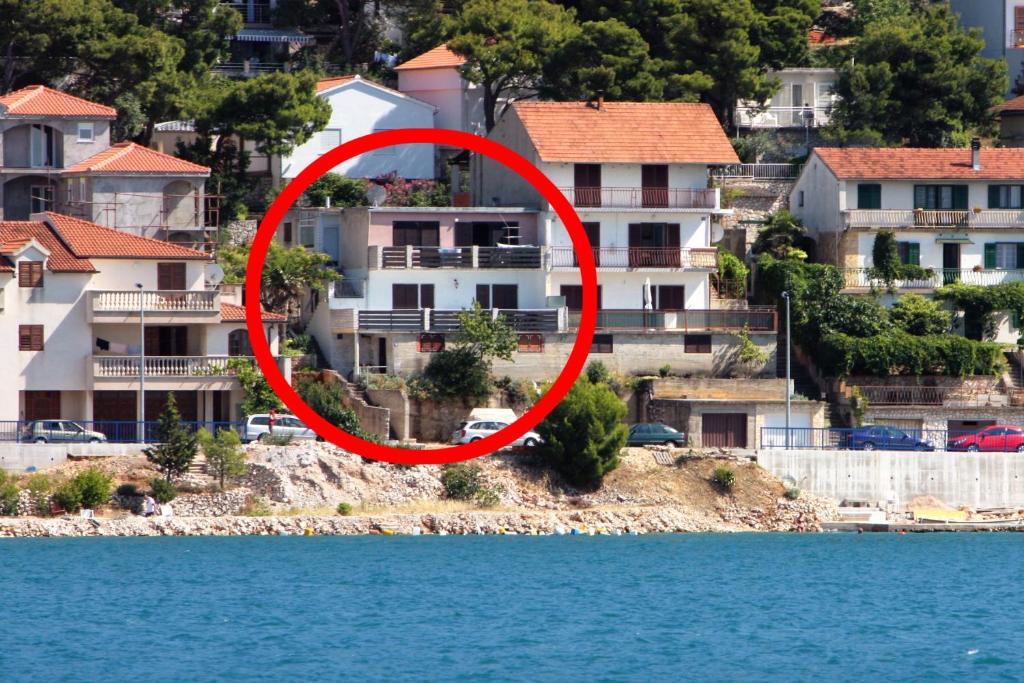 un cercle rouge devant certaines maisons sur l'eau dans l'établissement Apartments by the sea Tisno, Murter - 6106, à Tisno