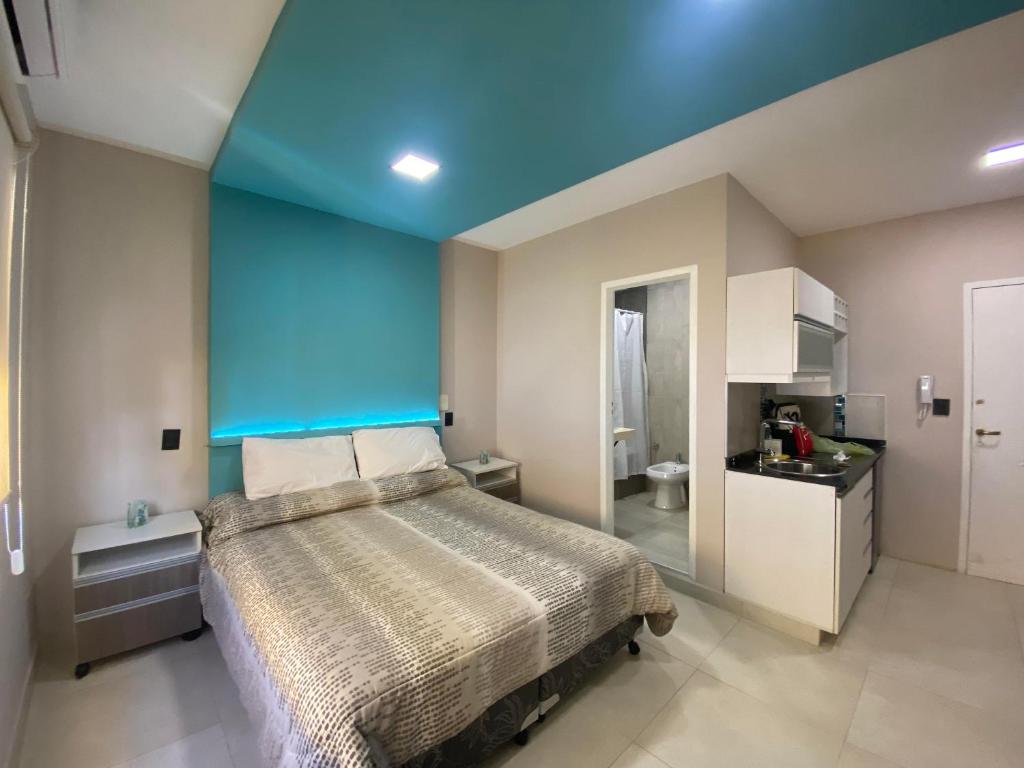 een slaapkamer met een bed met een blauw plafond bij Pia II in Salta