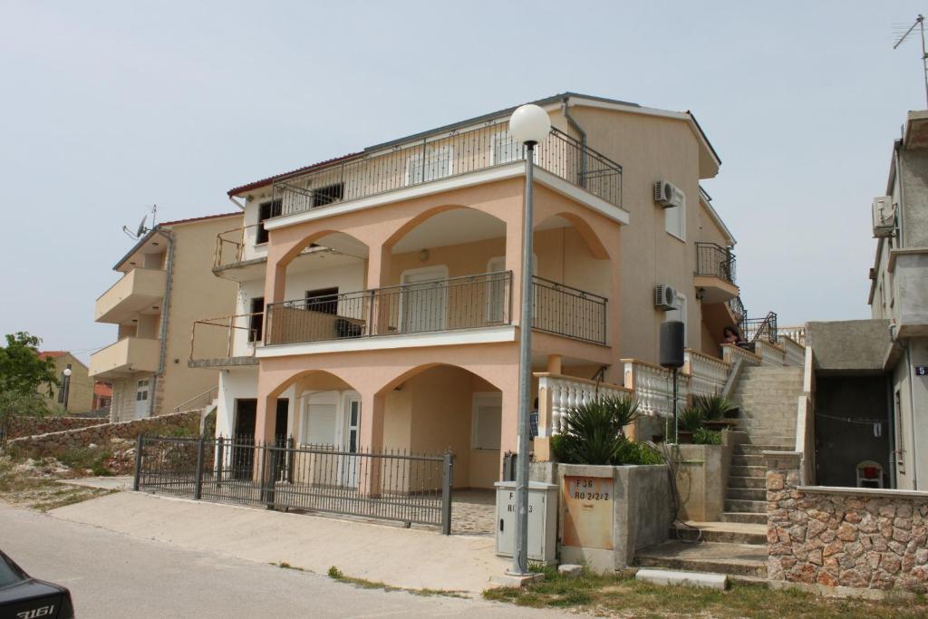 an apartment building with a staircase in front of it at Apartments with a parking space Sveti Petar, Biograd - 6169 in Sveti Petar