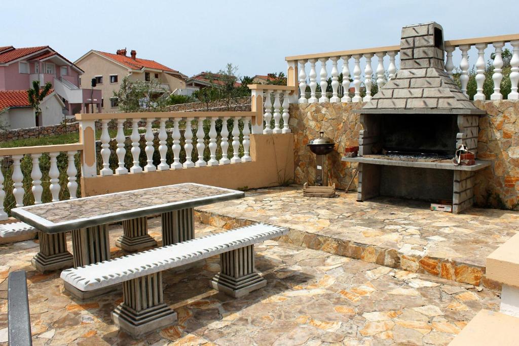 a stone patio with two benches and a fireplace at Apartments with a parking space Sveti Petar, Biograd - 6169 in Sveti Petar
