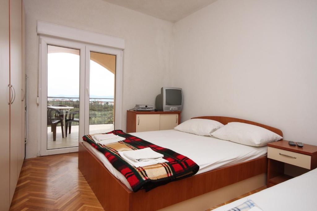 a bedroom with a bed and a balcony with a table at Apartments with a parking space Sveti Petar, Biograd - 6169 in Sveti Petar