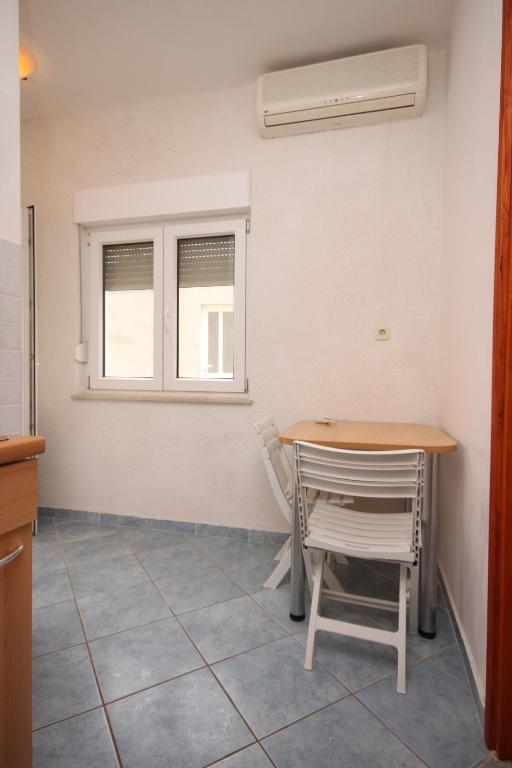 a table and chairs in a kitchen with a window at Apartments with a parking space Sveti Petar, Biograd - 6169 in Sveti Petar