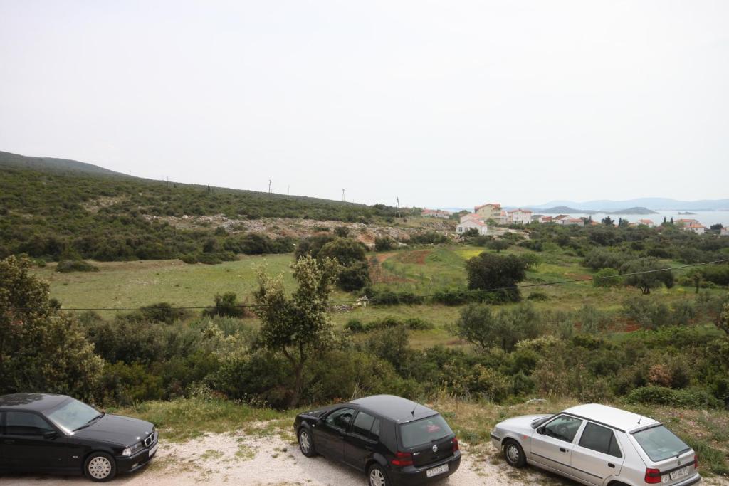 two cars parked on a dirt road in a field at Apartments with a parking space Sveti Petar, Biograd - 6169 in Sveti Petar