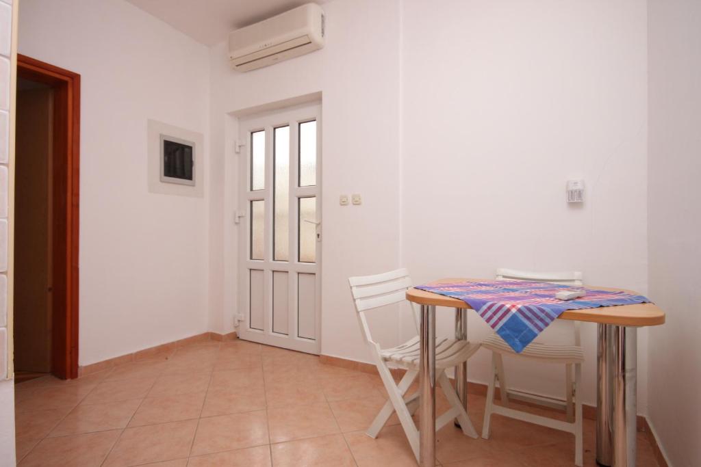 a dining room with a table and two chairs at Apartments with a parking space Sveti Petar, Biograd - 6169 in Sveti Petar
