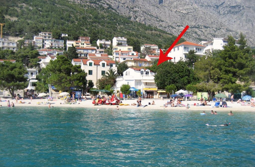 un gruppo di persone su una spiaggia vicino all'acqua di Apartments by the sea Baska Voda, Makarska - 6081 a Baška Voda