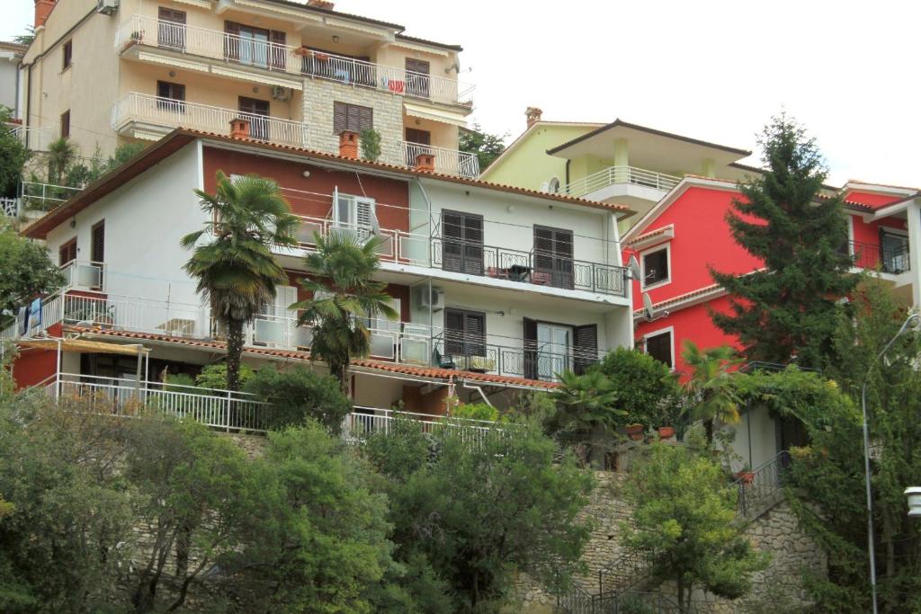 a building with palm trees in front of it at Apartments with WiFi Rabac, Labin - 7472 in Rabac