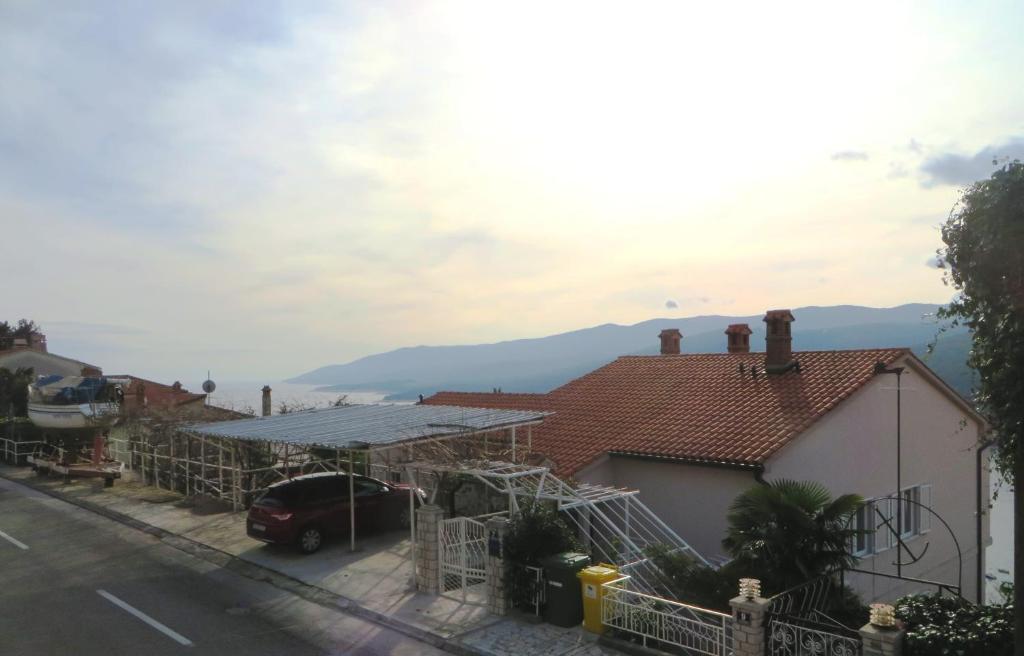 a house with a car parked in front of it at Apartment Rabac 7410e in Rabac