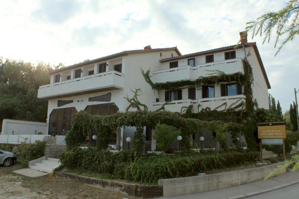 a large white building with ivy on it at Rooms with a parking space Premantura, Medulin - 7463 in Medulin