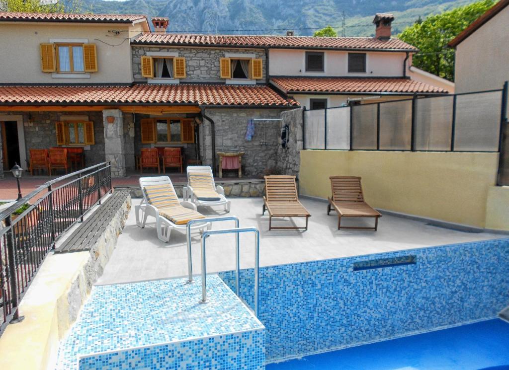 a swimming pool with chairs and a house at Holiday house with a swimming pool Kozljak, Central Istria - Sredisnja Istra - 7409 in Plomin