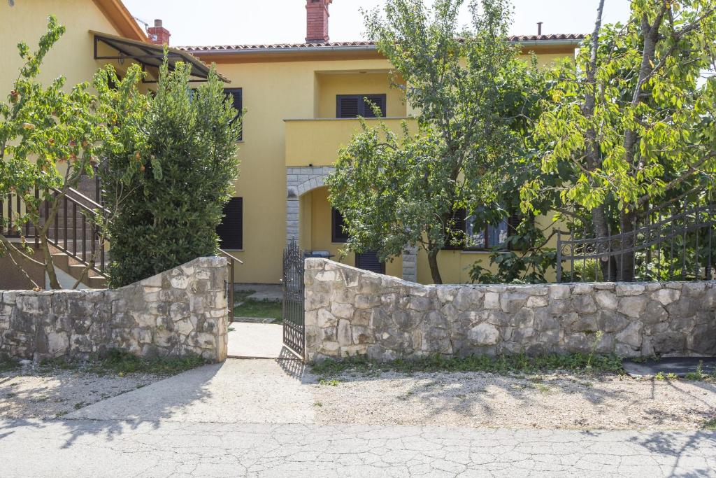 a stone retaining wall in front of a house at Apartment Vinez 7471a in Labin