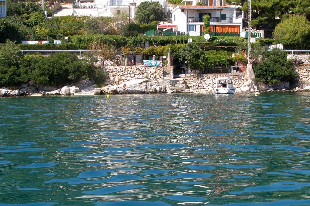 uma vista para um corpo de água com casas em Apartments by the sea Seget Vranjica, Trogir - 7509 em Seget Vranjica