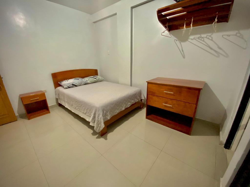 Dormitorio pequeño con cama y vestidor en La Terraza Hospedaje, en Moyobamba