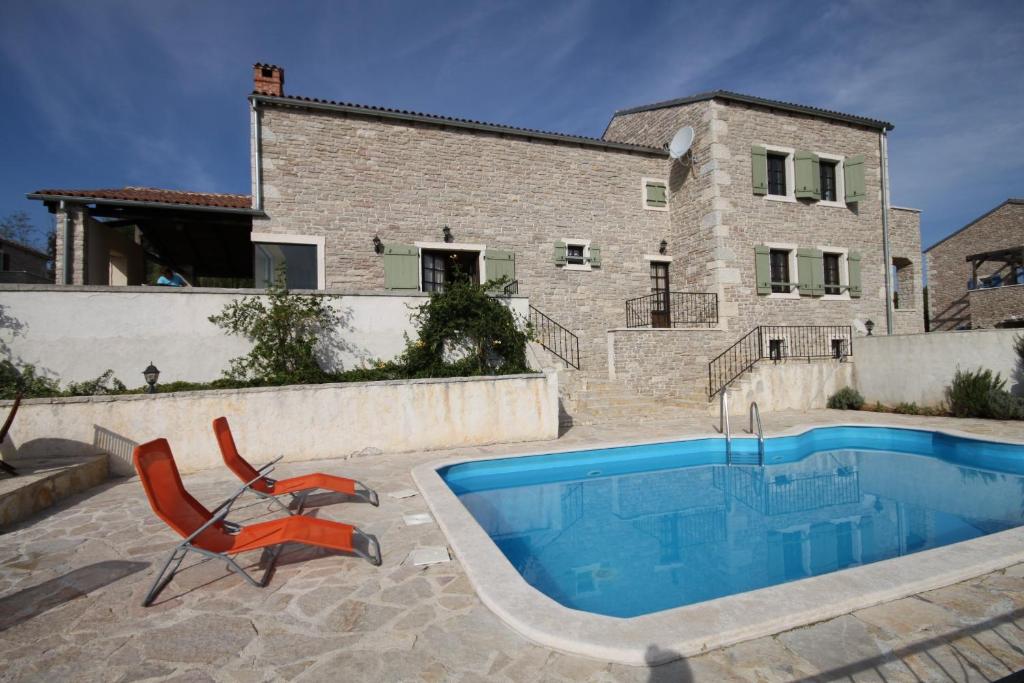 a villa with a swimming pool in front of a house at Luxury villa with a swimming pool Skrapi, Central Istria - Sredisnja Istra - 7525 in Brajkovići