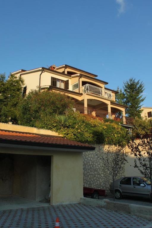 a house with a bench on top of a building at Apartments with a parking space Rabac, Labin - 7442 in Rabac