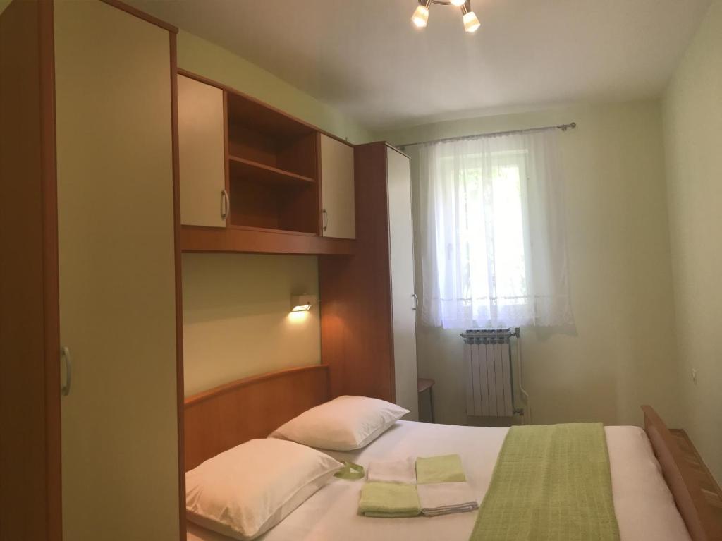 a small bedroom with a bed and a window at Apartments with a parking space Rabac, Labin - 7442 in Rabac