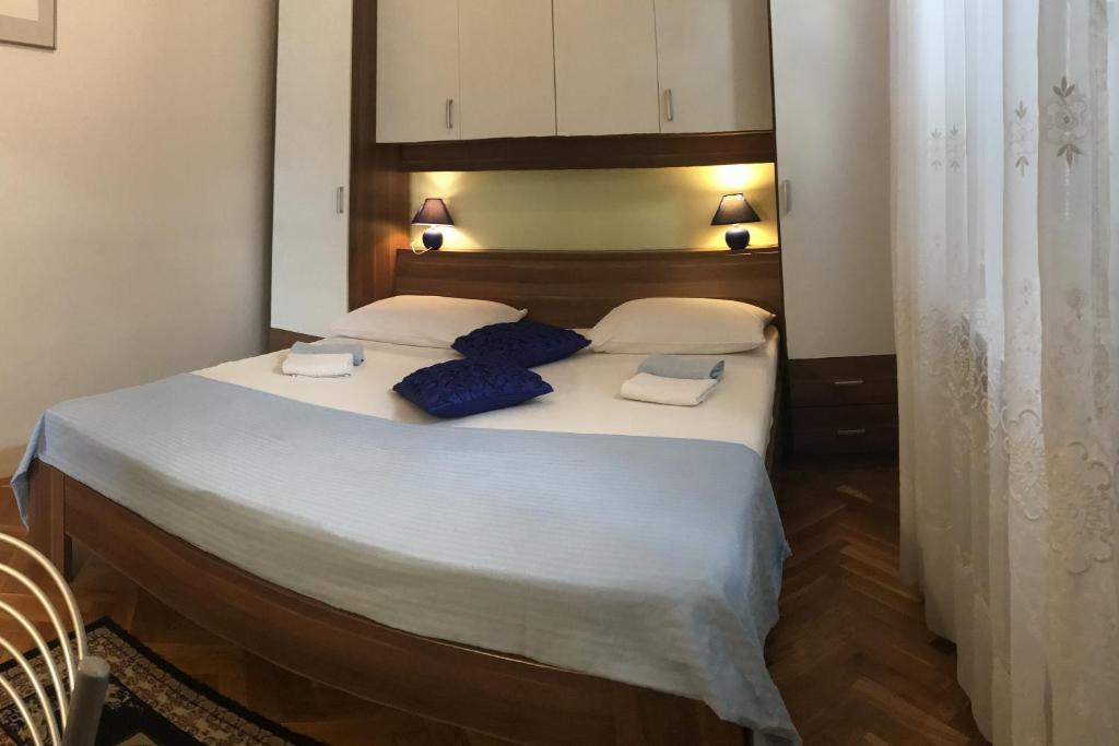 a bedroom with a large bed with blue pillows on it at Apartments with a parking space Rabac, Labin - 7442 in Rabac