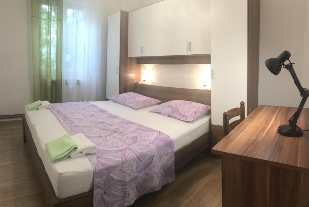 a bedroom with a bed with purple sheets and a desk at Apartments with a parking space Rabac, Labin - 7442 in Rabac