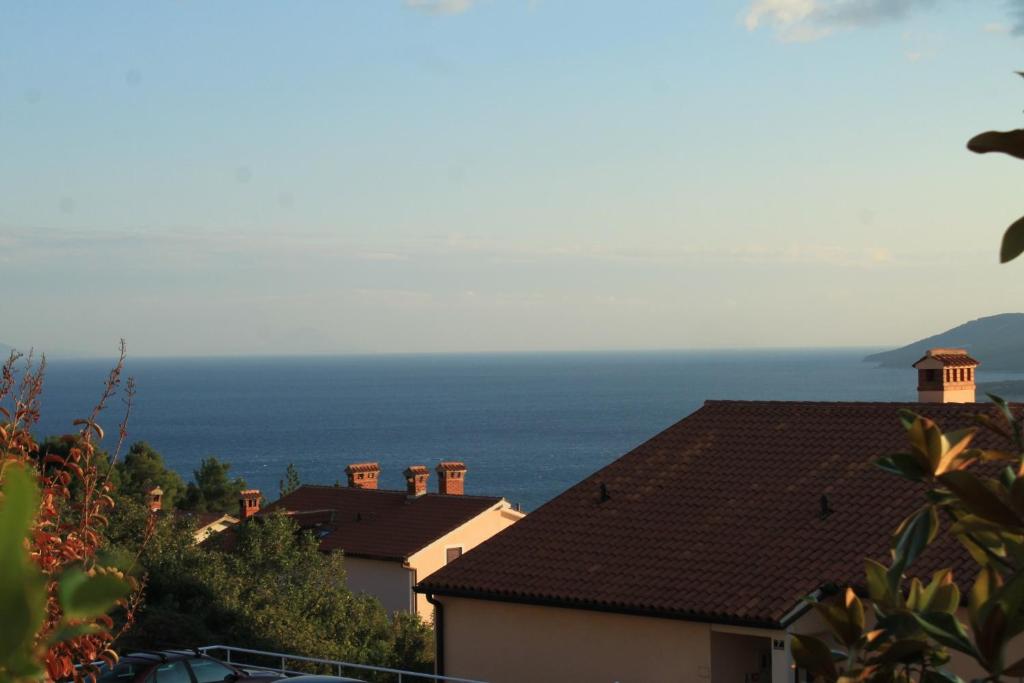 a group of houses with the ocean in the background at Apartments with a parking space Rabac, Labin - 7442 in Rabac