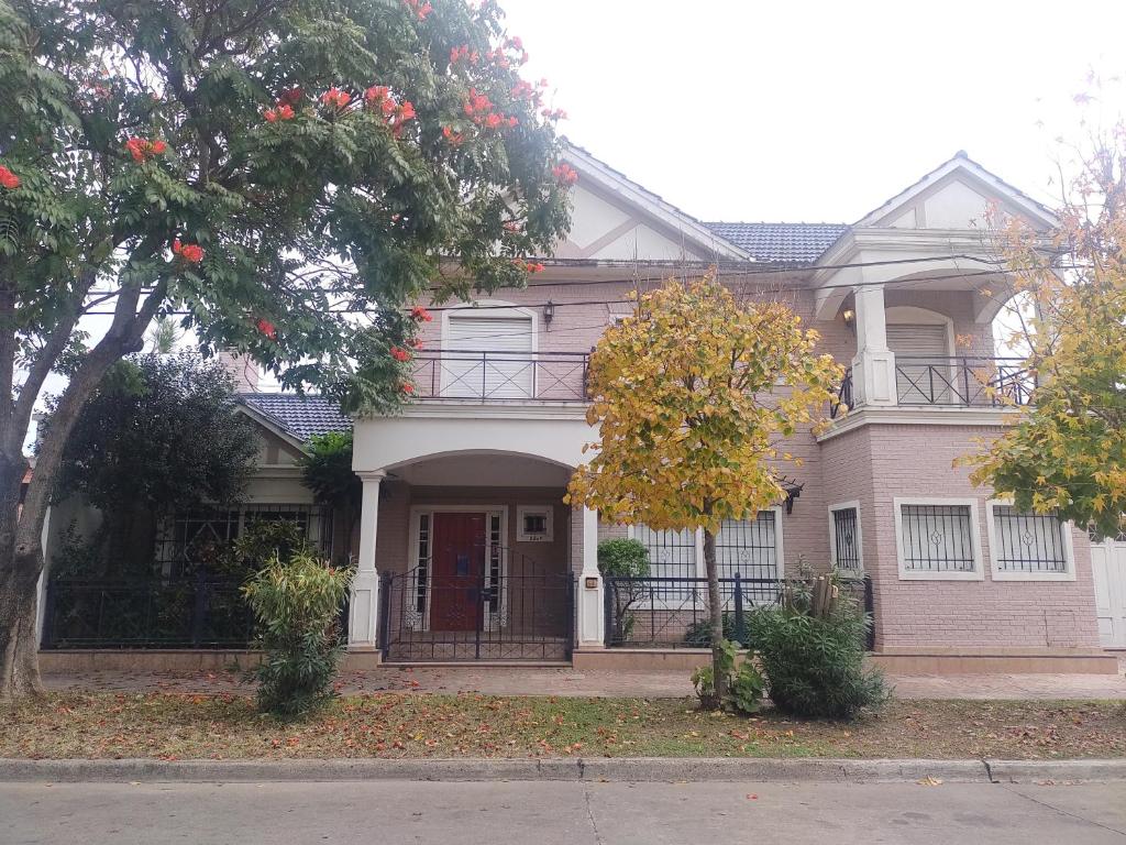 a large pink house with a balcony on a street at OLO Hostel in Santa Fe