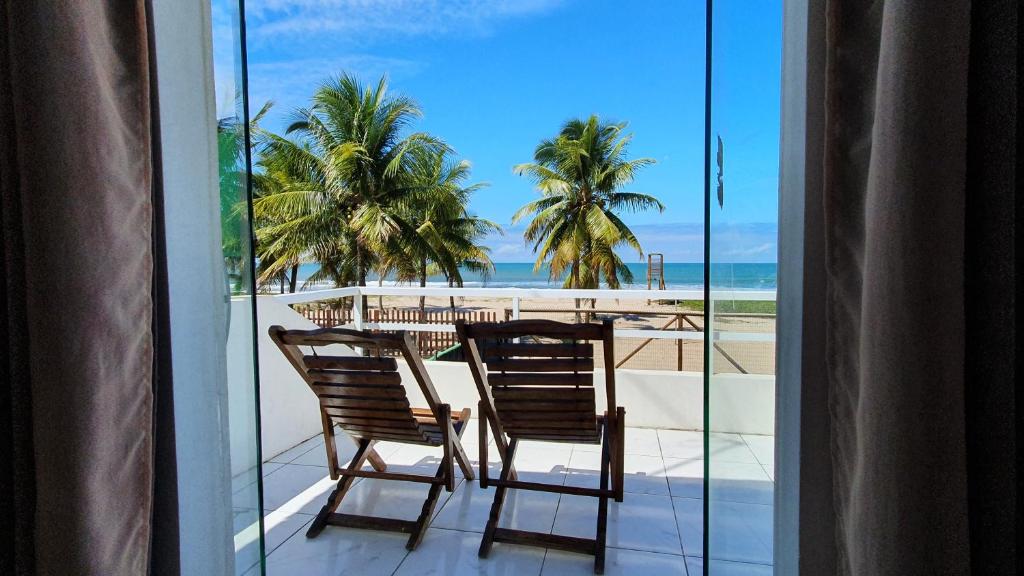 balcón con mesa y sillas y la playa en Pousada Sol Nascente, en Guaibim