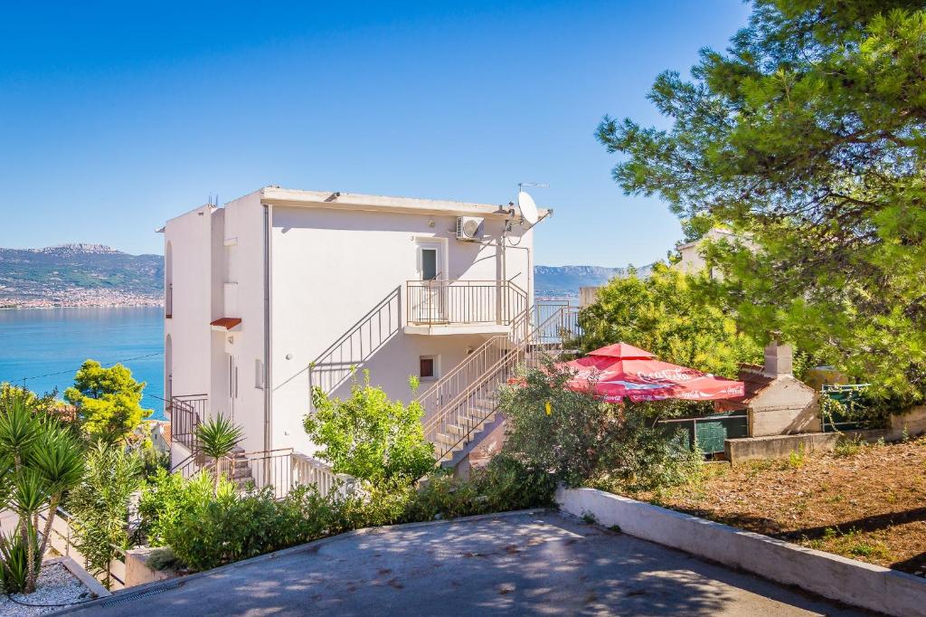 een gebouw met een balkon en uitzicht op het water bij Apartment Arbanija 7543a in Trogir