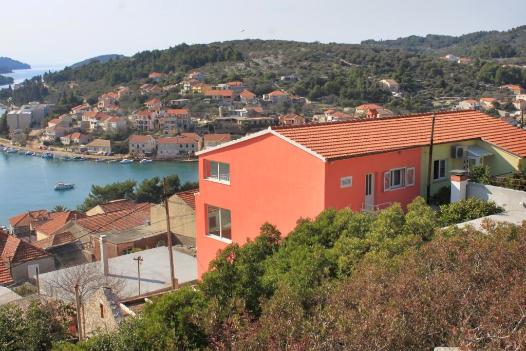 a house on a hill next to a body of water at Apartments with a parking space Vela Luka, Korcula - 7551 in Vela Luka
