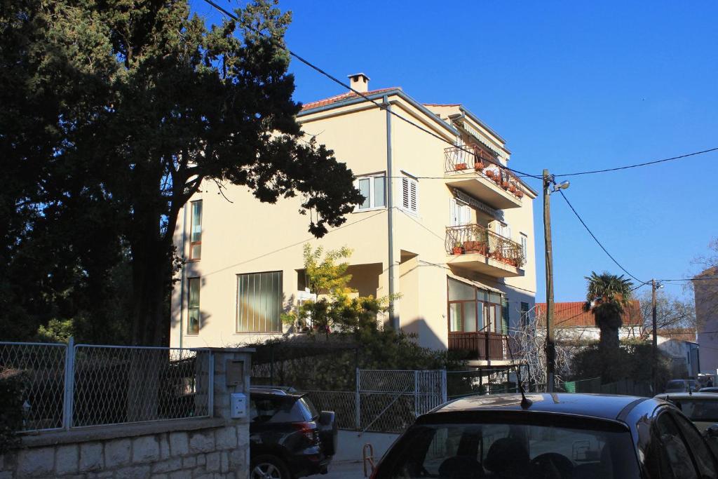 a white house with cars parked in front of it at Apartments with a parking space Split - 7569 in Split